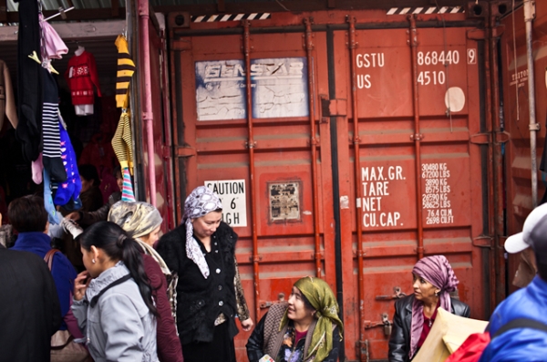 A group of Kyrgyz female traders chat and laugh in front of storage containers that are often used as storefronts in bazaars across Kyrgyzstan.  (Sue Anne Tay)