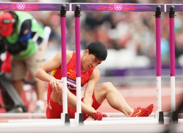 Liu Xiang of China sits on the track after getting injured in the Men's 110m Hurdles Round 1 Heats on Day 11 of the London 2012 Olympic Games at Olympic Stadium on August 7, 2012 in London, England. (Ezra Shaw/Getty Images)