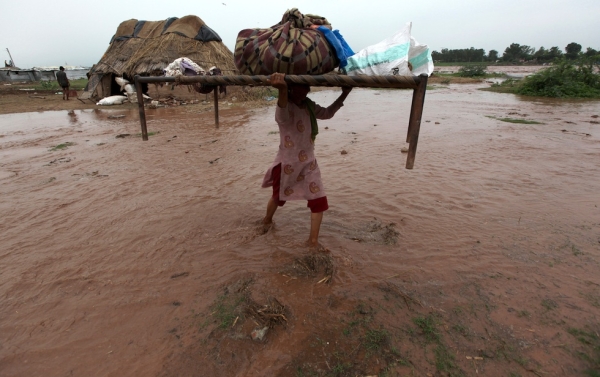 Indian woman carries her belongings during flash flood of the Tawi River near Jammu on August 4, 2012. (STRDEL/AFP/GettyImages)