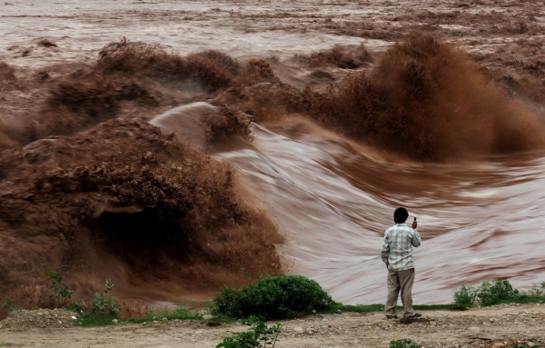 An Indian villager observes the flash flood of the Tawi River near Jammu on August 4, 2012. (STRDEL/AFP/GettyImage)