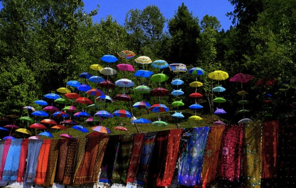 A colorful display of tie dyed scarves and umbrellas by the roadside. (Aamir Choudhry/Flickr)