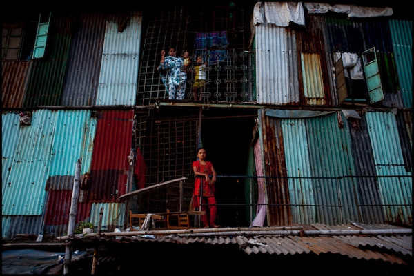 Residents of a slum apartment complex stand watchful in Dhaka, Bangladesh on August 25, 2012. (Zoriah/Flickr)