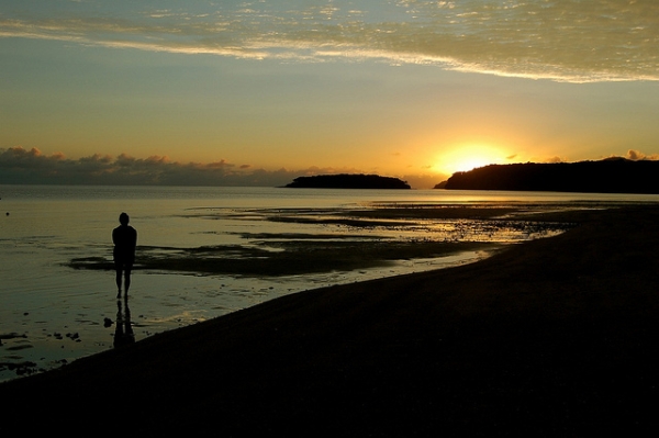 A woman takes in the sunrise off the coast of the Kadavu Island, Fiji on June 29, 2012. (bdearth/Flickr)