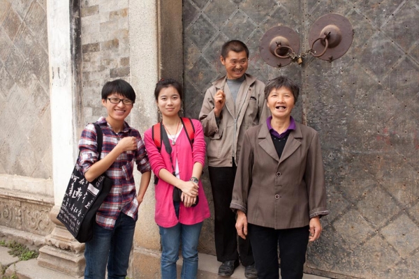 Four members of the installation team standing in front of Guanyu Tang, the ancestral hall in Pingshan Village built to honor Shu family ancestors dating to the Ming dynasty. L to R: Festival volunteers from Anhui University, Jiang Caijie and Qian Jinyue, and Pingshan locals, Mr. Shu and Ms. Shu. (Leah Thompson)