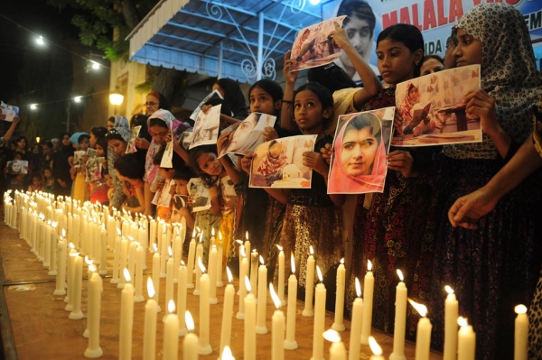 Malala Yousufzai, a 15-year-old Pakistani activist, was shot by the Taliban on October 9, 2012 for promoting girls' education. Her supporters held her photographs as they stood alongside burning candles at a ceremony to mark "Malala Day" in Karachi on November 10, 2012. (Rizwan Tabassum/AFP/Getty Images)