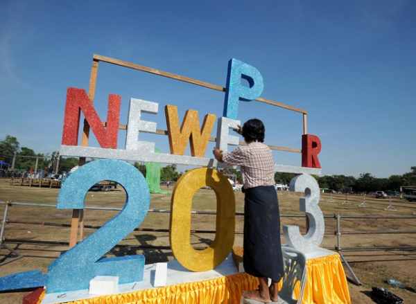 A worker puts up a sign to bring in the new year ahead of Myanmar's first public New Year countdown celebration at the Myoma grounds in Yangon, Myanmar on December 31, 2012. (Soe Than WIN/AFP/Getty Images)