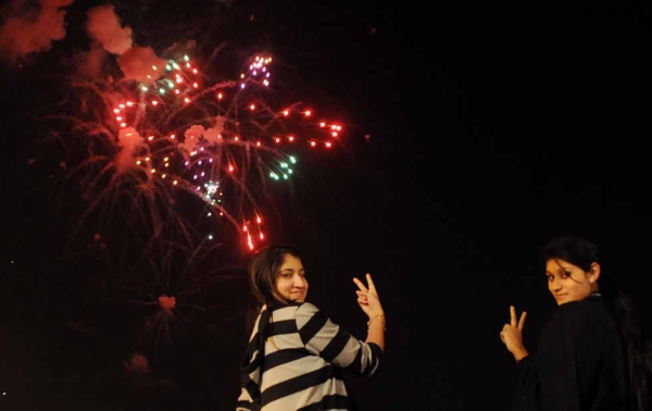 Two girls pose for a photograph during a fireworks display at Clifton Beach in Karachi, Pakistan to celebrate the New Year early on January 1, 2013. (Asif Hassan/AFP/Getty Images)