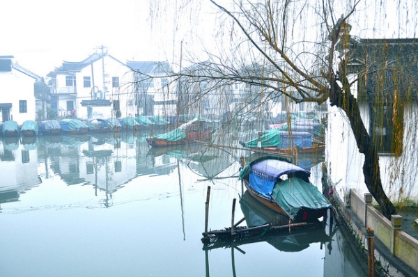 Boats rest under a drooping tree in the still waters of Zhouzhuang, China on January 14, 2013. (Sharon Hahn Darlin/Flickr)