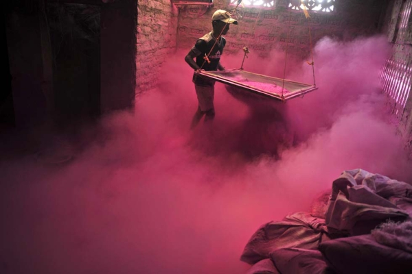 An Indian worker sifts colored powder, known as "gulal," to be used during Holi, the Festival of Colors on the outskirts of Siliguri, India on March 20, 2013. (Diptendu Dutta/AFP/Getty Images)