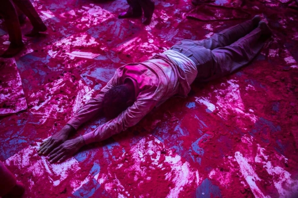 A man slides on a floor covered in pink powder during Holi celebrations in Mathura, India on March 22, 2013. (Daniel Berehulak/Getty Images)