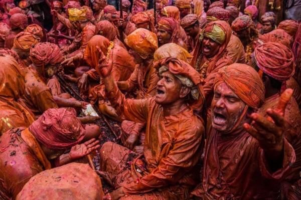 Hindu devotees drenched in orange sing during Holi celebrations in the village of Nundgaon near Mathura, India on March 22, 2013. (Daniel Berehulak/Getty Images)
