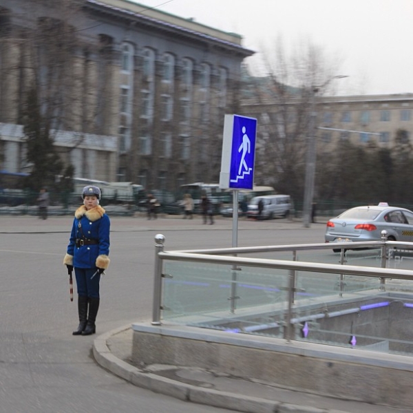 Jean H. Lee's photographs capture scenes of everyday life in North Korea. Here a traffic controller stands next to some of the new railings and signs going up at underpass entrances across Pyongyang. (newsjean/Instagram)