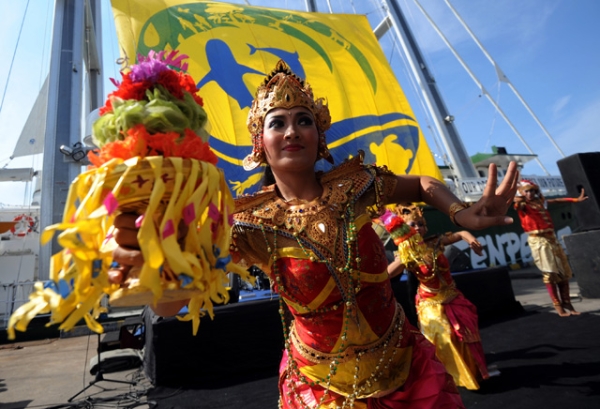 Dancers clad in vibrant colors perform during a welcoming ceremony to greet Greenpeace's Rainbow Warrior ship in Bali, Indonesia on May 31, 2013. (Sonny Tumbelaka/AFP/Getty Images)