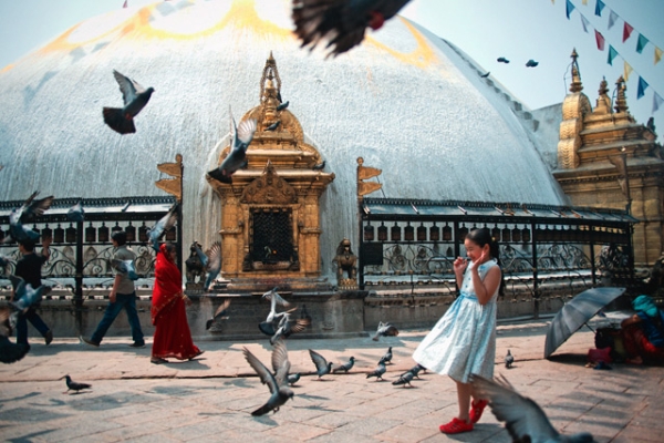A young girl holds her ground amidst a flock of pigeons in Kathmandu, Nepal on May 10, 2013. (Elliot Scott/Flickr)