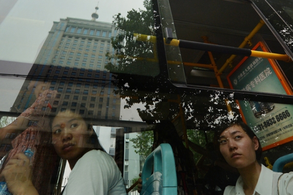 Commuters look at the Intermediate People's Court — where Bo Xilai was indicted and his case is expected to be heard — reflected in a bus window in Jinan, Shandong province on July 25, 2013. (Mark Ralston/AFP/Getty Images)