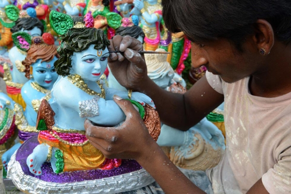 Indian artist Suresh paints an idol of the Hindu Lord Krishna at a roadside stall on the outskirts of Amritsar on August 25, 2013. (Narinder Nanu/AFP/Getty Images)