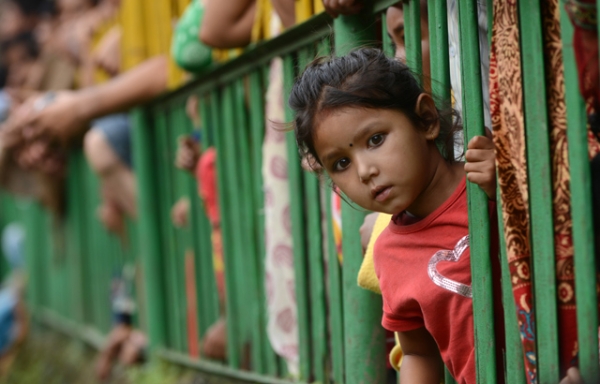 A child leans out from behind a barrier to watch a competition on the outskirts of Kathmandu, Nepal on August 23, 2013. (Prakash Mathema/AFP/Getty Images)