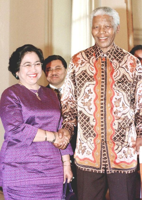 Indonesian President Megawati Sukarnoputri (L) shakes hands with visiting former South Africa president Nelson Mandela (R) at the state palace in Jakarta on October 2, 2002. (Oka Budhi/AFP/Getty Images)