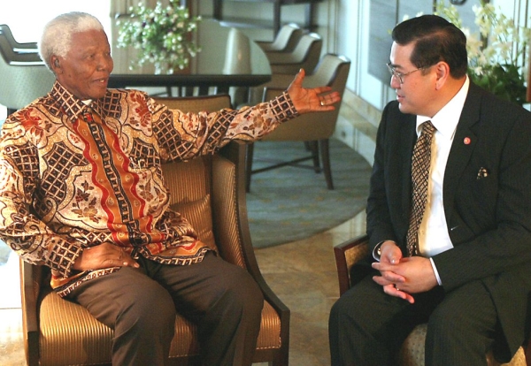 Former South African President Nelson Mandela (L) talks with Thai Foreign Minister Surakiart Sathirathai (R) at a hotel in Bangkok on July 14, 2004. (Pornchai Kittiwongsakul/AFP/Getty Images)