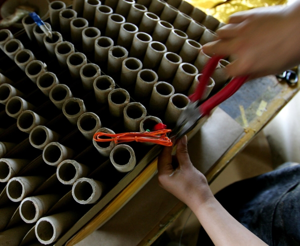 On June 21, 2006, a woman inserts fuses into firework cartridges at Tanghua Factory in Liuyang City, located in the Hunan province of China. (Guang Niu/Getty Images) 

