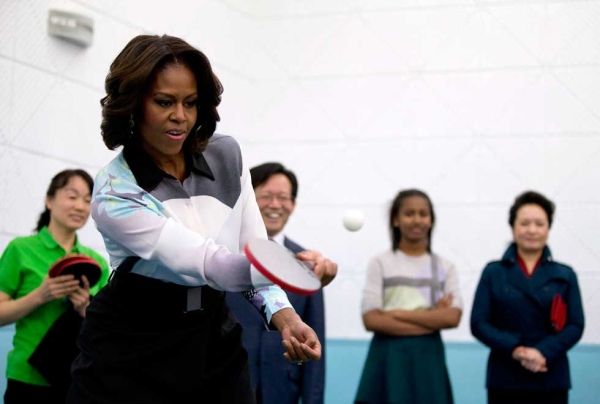 Michelle Obama plays table tennis as Peng Liyuan, wife of Chinese President Xi Jinping (R), looks on during their visit to the Beijing Normal School on March 21, 2014. (Andy Wong-Pool/Getty Images) 