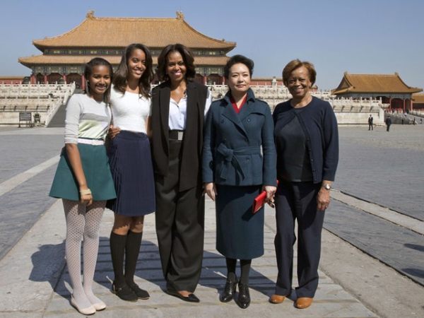 U.S. First Lady Michelle Obama (C), her daughters Sasha (L), Malia (2nd L), her mother Marian Robinson (R) and Peng Liyuan, wife of Chinese President Xi Jinping, pose for photographers in Beijing's Forbidden City on March 21, 2014. 