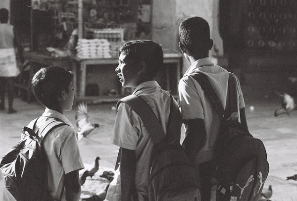 Three school boys walk and talk on a street in Nagore, India on May 1, 2014. (Nagoor Dargah/Flickr)