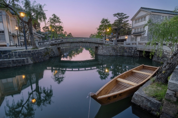A boat is tied near a stone bridge at dusk in the Kurashiki Bikan Historical District, Japan on April 25, 2014. (Les Taylor/Flickr)