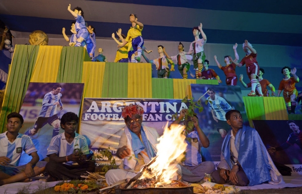 In Kolkata on June 15, 2014, a Hindu priest (C, bottom) performs a special religious prayer organized by Indian fans of Argentina ahead of Argentina's first match at the 2014 World Cup. (Dibyangshu Sarkar/AFP/Getty Images)
