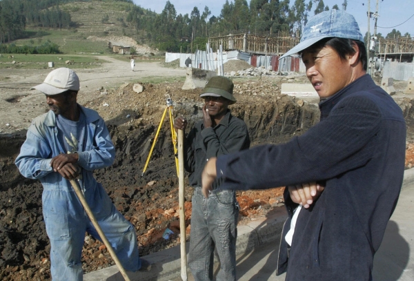 A Chinese construction worker (R) supervises the building of a road on 30 April 2007 in Makenisa, 9km south of Addis Ababa, Ethiopia. (Simon Maina/AFP)