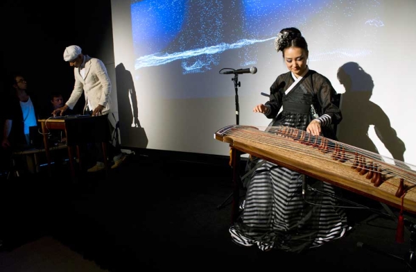 DJ Spooky aka Paul D. Miller (L) performs "Paik Variations 1-3," mixing video and music live with his iPad, accompanied by Korean gayakeum player Rami Seo, on Sept. 8, 2014. (Elena Olivo/Asia Society)