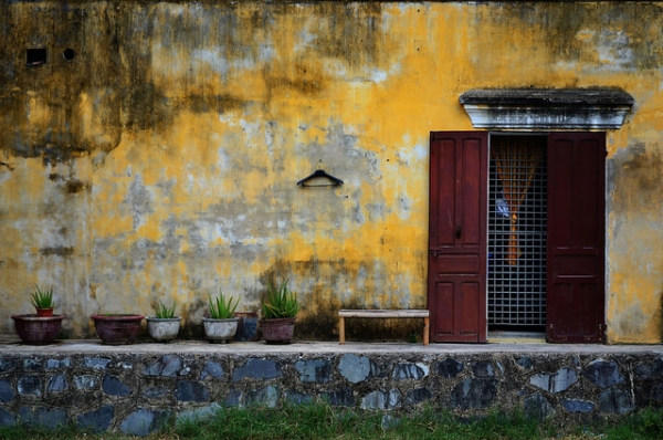A lone hanger hangs off a decaying yellow wall in Hoi An, Vietnam on September 11, 2014. (Claire Backhouse/Flickr)