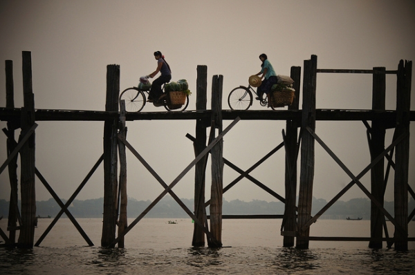 Two people cycle their way across the U Pain Bridge, built over 2000 years ago, in Mandalay, Myanmar on October 10, 2014. (Rajesh_India/Flickr)