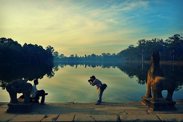 Against the setting sun, a photographer stops to take a photo in Angkor Wat, Cambodia on February 6, 2015. (Roberto Trm/Flickr)