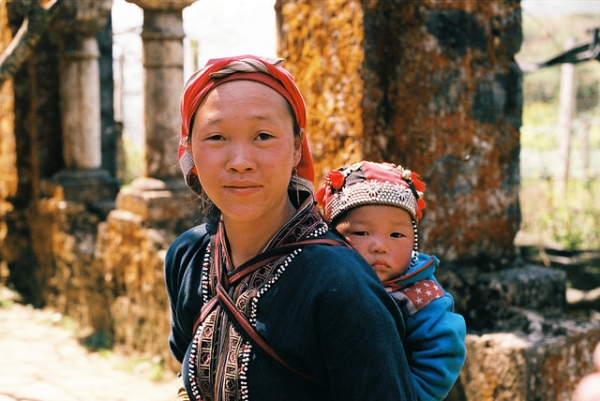 A young mother poses for a photograph with her child on her back in Sapa, Vietnam on February 28, 2015. (Thế Long Nguyễn/Flickr)
