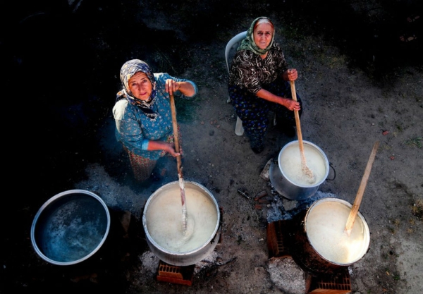 Women of Izmir, Turkey, stir cauldrons of keşkek, a wheat and meat dish prepared for weddings, circumcisions, and religious holidays. Photograph by Hakan Yayla. (Smithsonian.com)
