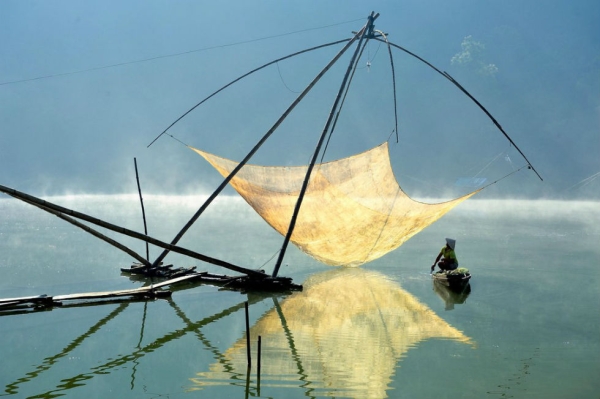 A fisherman checks his net in the early morning in Lam Dong, Dalat, Vietnam. Photograph by Hoang Long Ly. (Smithsonian.com)