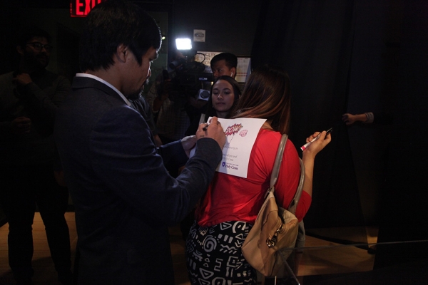 Manny Pacquiao signs an autograph for a fan at Asia Society Museum on Monday, October 12, 2015. (Ellen Wallop/Asia Society)