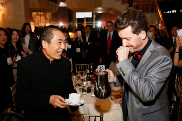 Emcee Jeff Locker (right) fulfills a dream to pour Zhang Yimou, director and Lifetime Achievement Award winner, a cup of coffee during the 2015 Asia Society U.S.-China Film Summit and Gala held at the Dorthy Chandler Pavilion in Los Angeles on November 5, 2015. (Ryan Miller/Capture Imaging)