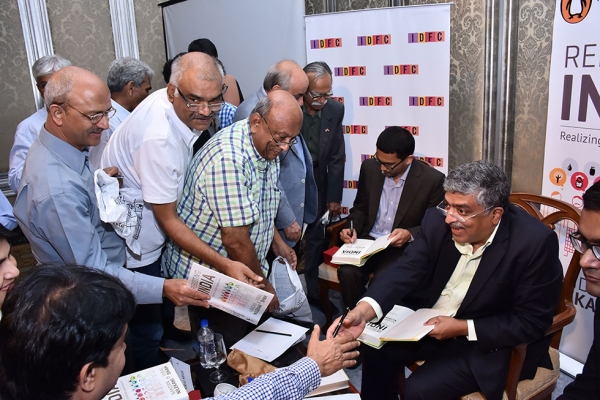 Nandan Nilekani, former chairman of the Unique Identification Authority of India (UIDAI) and co-founder of Infosys, and Viral Shah, founding partner of Julia Computing, sign books after a conversation at Asia Society's India Center in Mumbai on November 7, 2015. (Liberty Event Management/Asia Society)