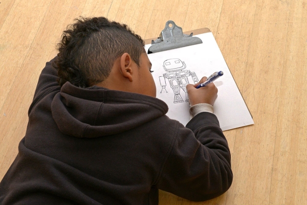 A New York City public school student sketches a robot during a visit to Asia Society Museum. Four of the city's public schools presented student artwork in response to an Asia Society exhibition “Inspired by Nam June Paik: Becoming Robot,” part of an annual exhibition presented in collaboration with Studio in a School. "Inspired by Nam June Paik" was on view at the museum from May 19 through July 19. (Elsa Ruiz/Asia Society)

