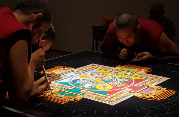 Monks start in the middle and work their way out during the painstaking construction of the sand mandala in Houston, Texas on August 21, 2015. (Tiffany Chen/Asia Society)