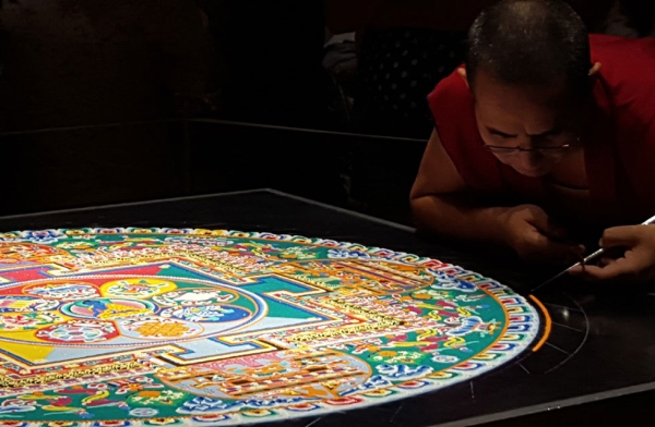 A monk adds some final touches on a sand mandala in Houston, Texas on August 21, 2015. (Tiffany Chen/Asia Society)