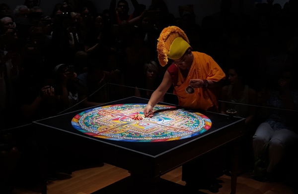 Following the ceremony, a monk begins the deconstruction of the sand mandala in Houston, Texas on August 23, 2015. (Tiffany Chen/Asia Society)