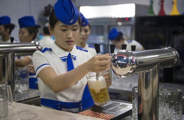 A waitress draws jugs of beer to serve before the opening of the Pyongyang Taedonggang Beer Festival. (Kim Won-jin/AFP/Getty Images)