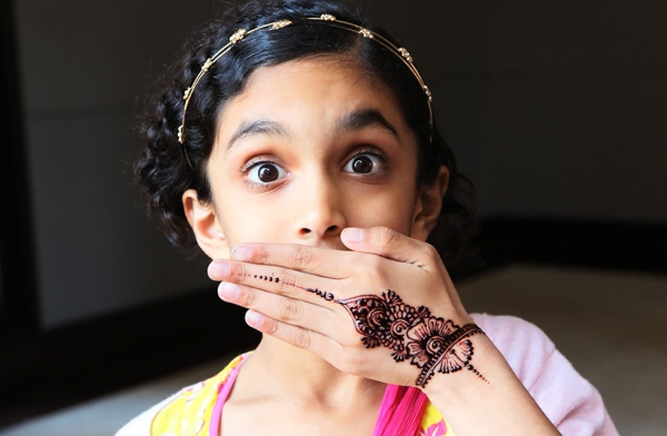 A young girl shows off the intricate henna design temporarily tattooed on her hand on October 15, 2016 in New York. (Ellen Wallop/Asia Society)