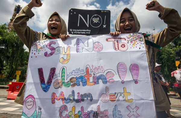 Girls from a local boarding school shout during an anti-Valentine's Day rally in Surabaya, East Java province, Indonesia on February 13, 2017. Conservative Indonesian Islamic groups have denounced Valentine's Day, saying it is un-Islamic, promoting promiscuity, casual sex, and consumption of alcohol. Some cities have outright banned the holiday, and this year there were even reports of authorities seizing condoms from some stores in order to prevent teenagers from having sex. (Juni Kriswanto/AFP/Getty)