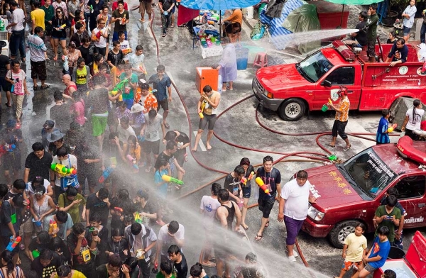 Thai fire fighters soak the crowd with their fire hoses during a community water fight on Silom Road as part of the Songkran water festival on April 14, 2013 in Bangkok, Thailand. (Jack Kurtz/Getty Images)
