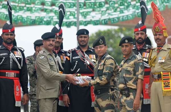 Pakistani Wing Commander Bilal (2L) presents sweets to Indian Border Security Force (BSF) Commandant Sudeep (4R) during a ceremony to celebrate Pakistan's Independence Day at the India-Pakistan Wagah border post on August 14, 2017. (Narinder Nanu/AFP/Getty)