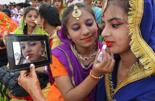 Indian students dressed as Punjabi giddha dancers apply each other's makeup during a full dress rehearsal for the 70th Independence Day, at Guru Nanak Stadium in Amritsar on August 13, 2017. (Narinder Nanu/AFP/Getty)